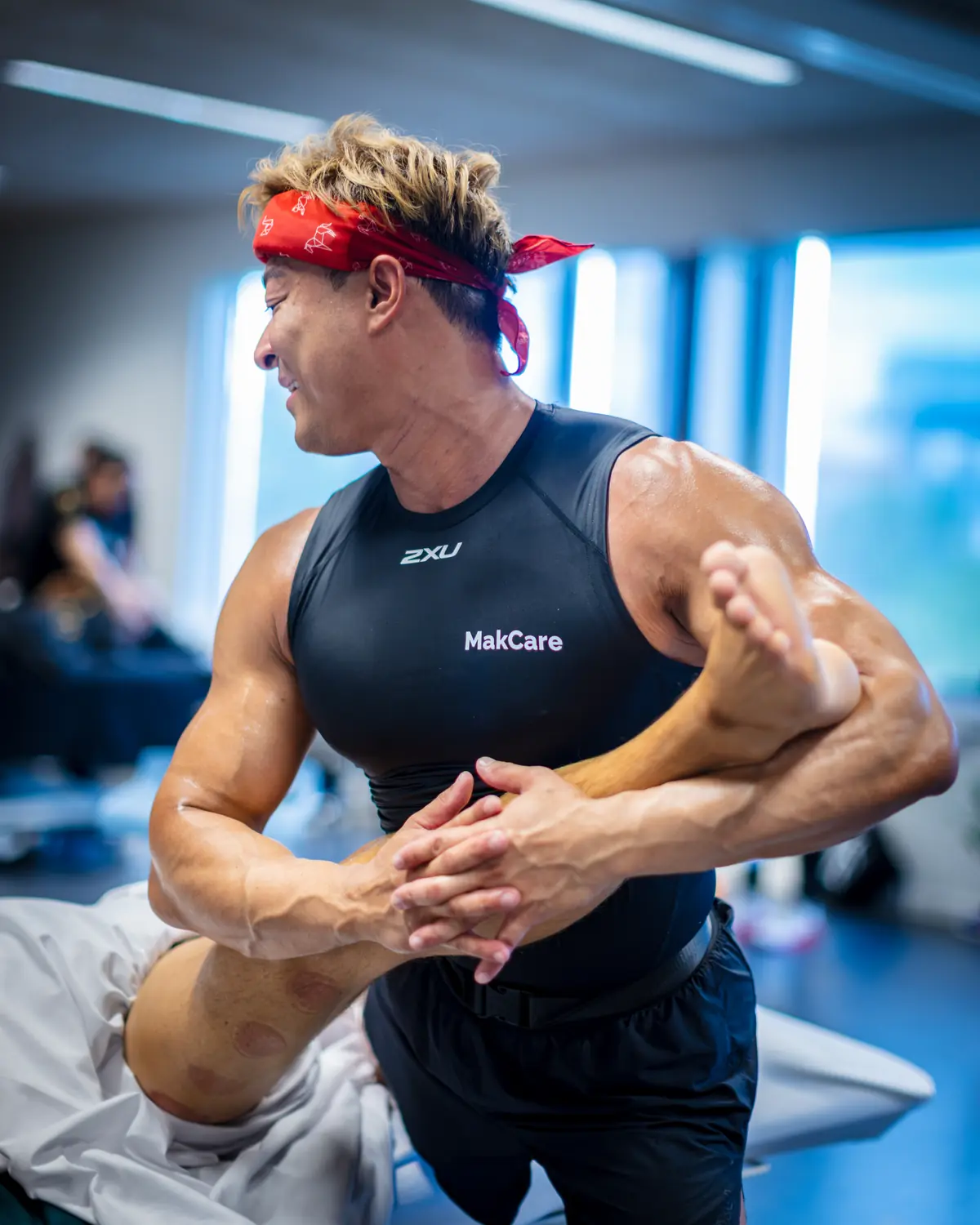 Hubert Mak lifting and stretching a client's leg